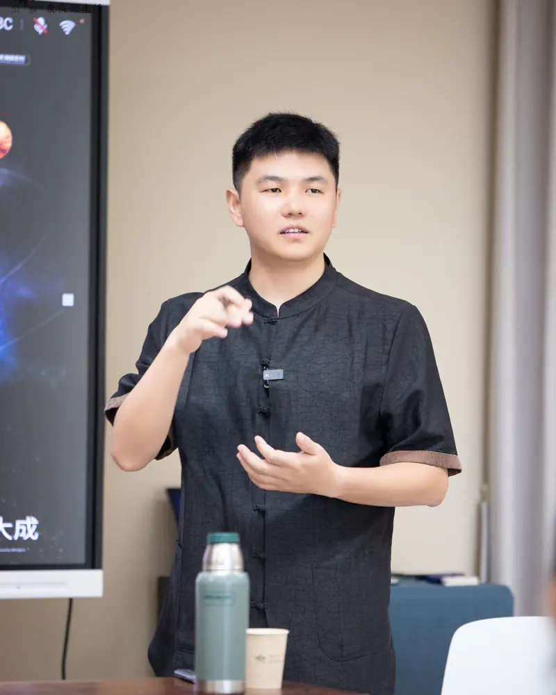 Facilitator explaining singing bowl technique with a hand demonstration