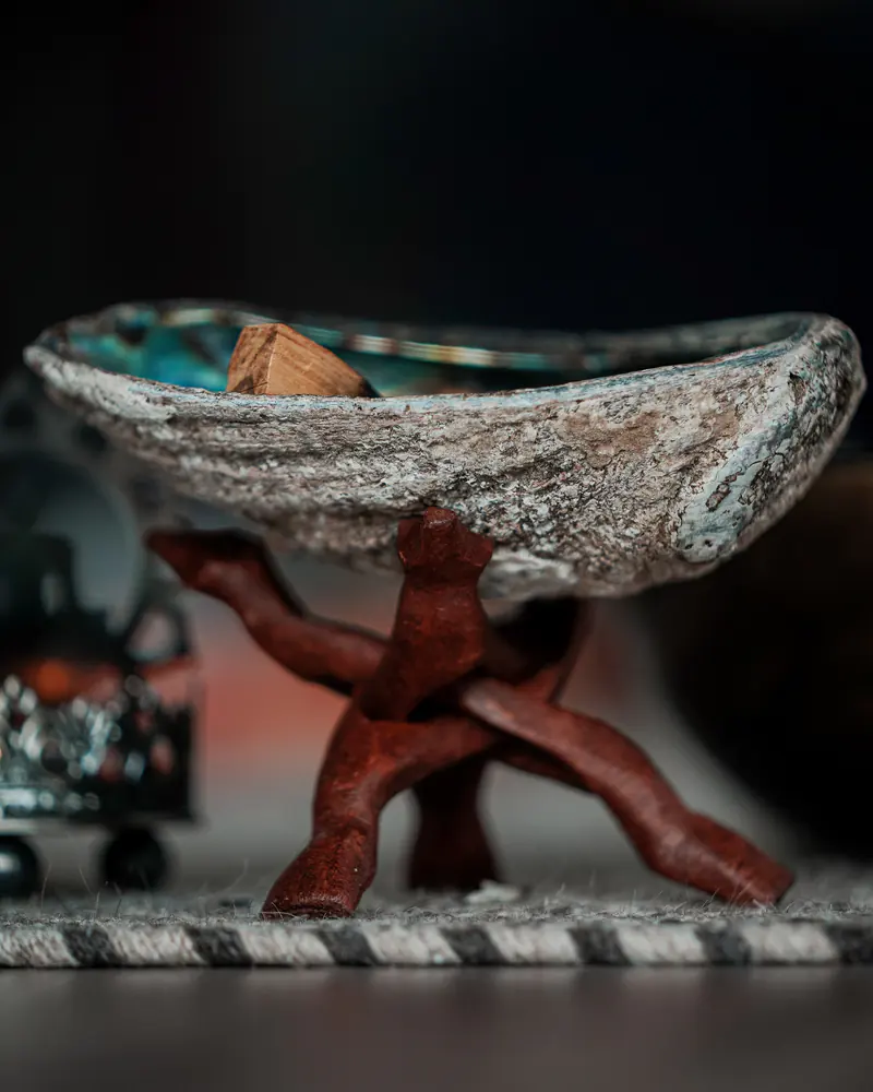 Hand holding an aged singing bowl with rim and surface details visible