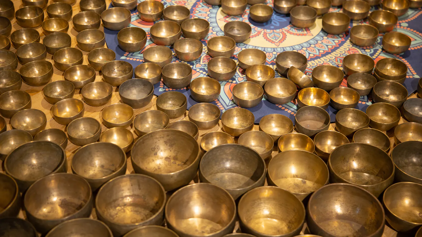 Rows of metal singing bowls arranged for comparing forms and sizes