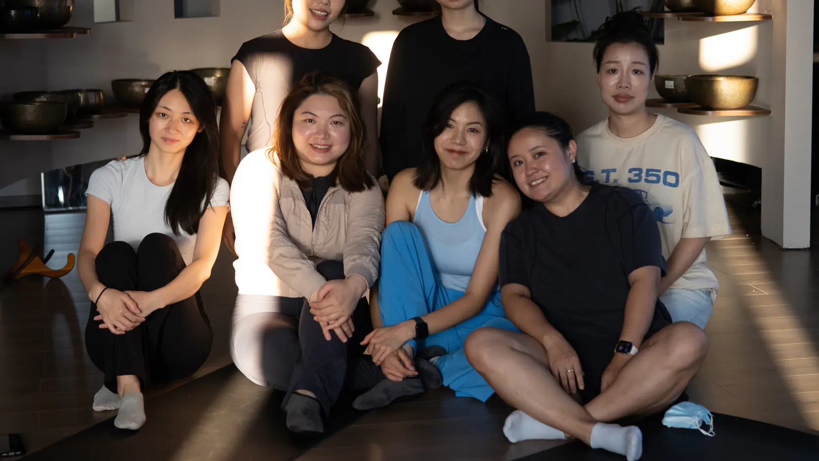 Participants photographed after an in-person sound-learning activity with singing bowls and practice instruments visible behind them